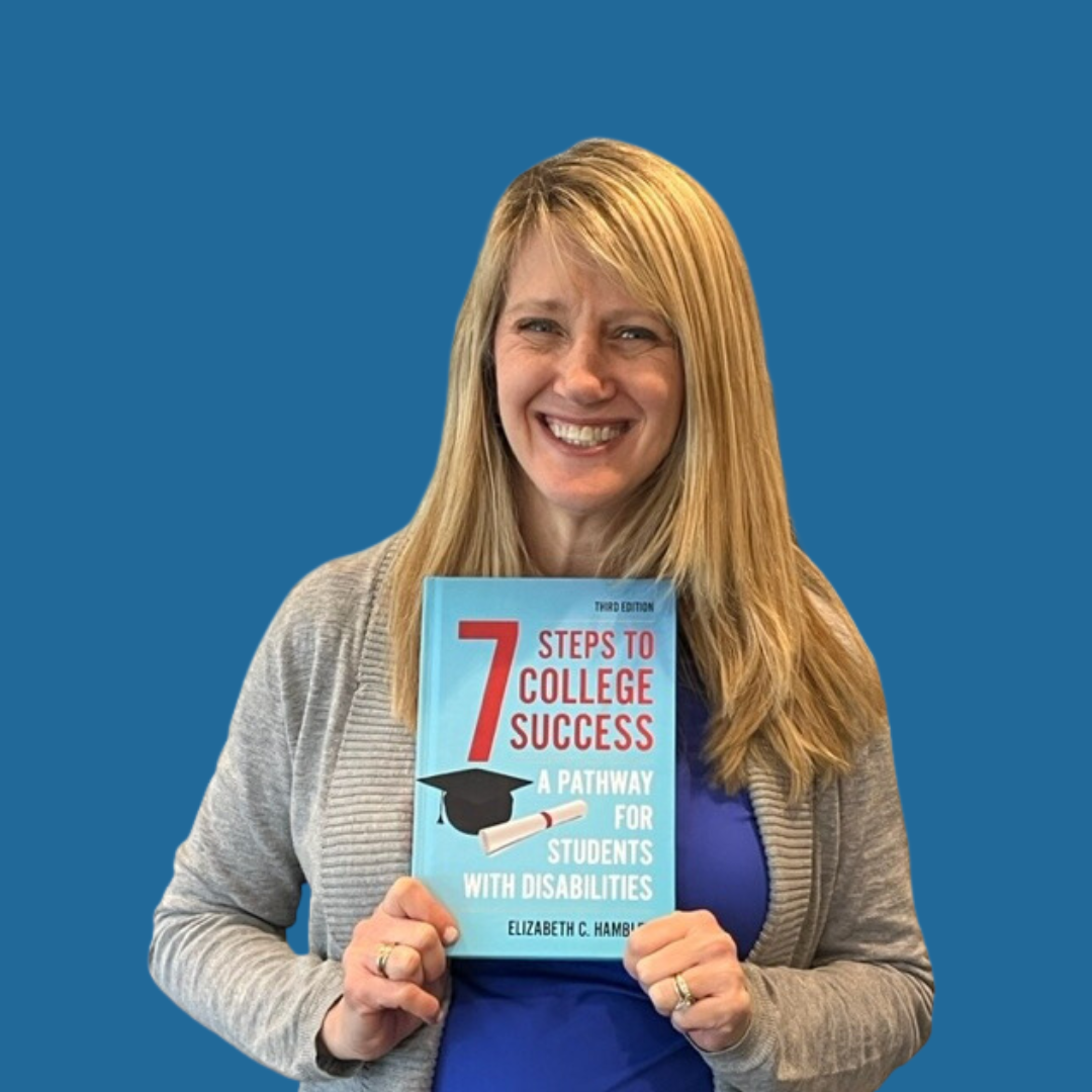 Elizabeth Hamblet, a white, blond, middle-aged woman, is wearing a grey cardigan. She is holding a copy of her book, Seven Steps to College Success: A Pathway for Students with Disabilities, and smiling.