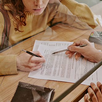 Signing Documents at Office Behind Glass Partition